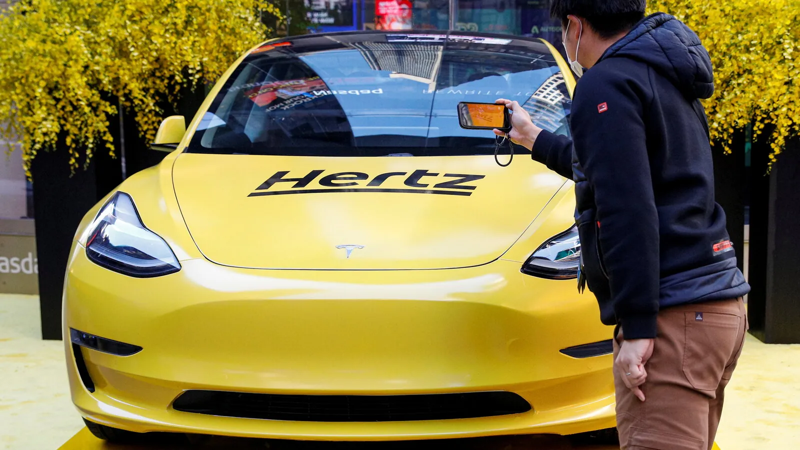Rows of Tesla electric vehicles parked in a Hertz rental lot