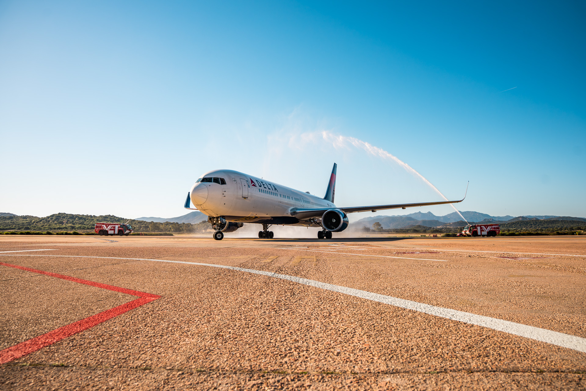 Delta aircraft passing through a ceremonial water cannon salute during an inaugural route arrival